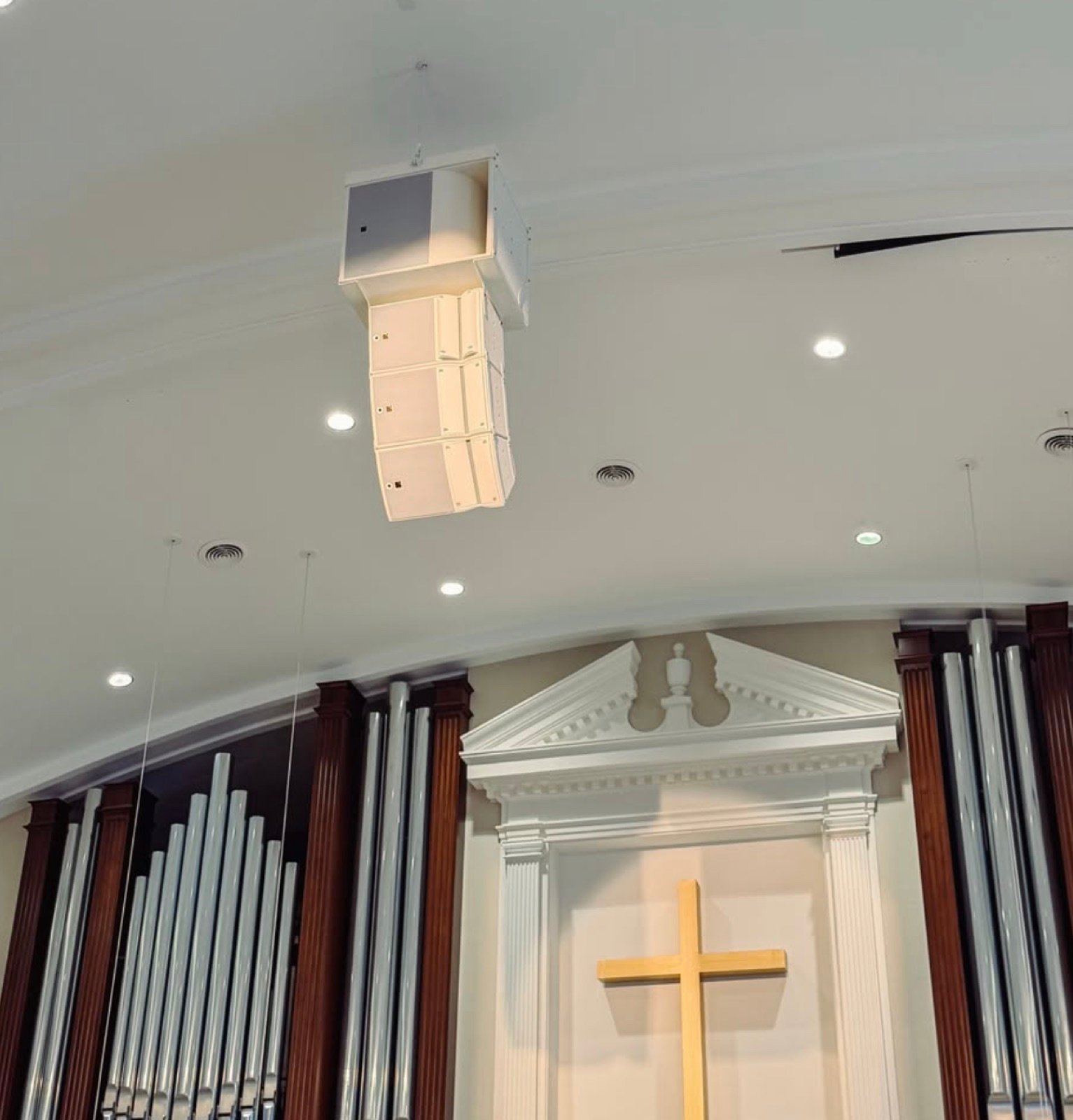 New line-array speakers mounted in the sanctuary ceiling above the organ pipes and cross